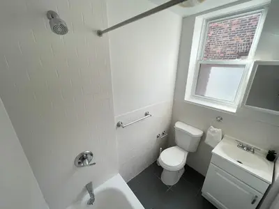 a white bathroom with a toilet and a sink at Park Hamilton House 3B Top Floor Apt Mins to NYC in Jersey City