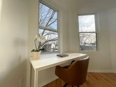 a white desk with a chair and two windows at Park Hamilton House 3B Top Floor Apt Mins to NYC in Jersey City