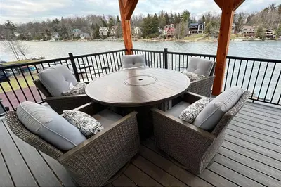 a patio with a table and chairs on a deck at 9 BR,34 Sleeps Skiing Lake Sauna Hottub Kayaks in Lake Harmony
