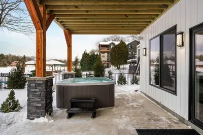a hot tub on the patio of a house at 9 BR,34 Sleeps Skiing Lake Sauna Hottub Kayaks in Lake Harmony