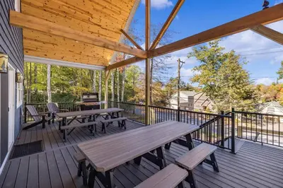 a large deck with benches and tables on it at New Luxe! 9BR,7BA, Elevator, Sleeps 30, EV Charger in Lake Harmony