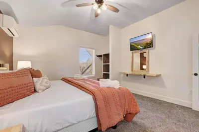 a bedroom with a bed and a flat screen tv at New Luxe! 9BR,7BA, Elevator, Sleeps 30, EV Charger in Lake Harmony