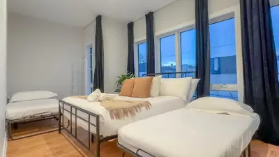 a bedroom with two beds and a large window at Pristine Pad, Sleep 12, Free parking, 3BRs, 20 PERCENT OFF in East Newark