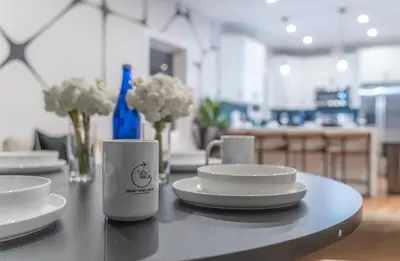 a table with two cups and plates and flowers at Pristine Pad, Sleep 12, Free parking, 3BRs, 20 PERCENT OFF in East Newark