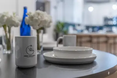 two coffee cups and a plate on a table at Pristine Pad, Sleep 12, Free parking, 3BRs, 20 PERCENT OFF in East Newark