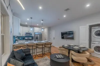 a living room with a couch and a kitchen at Pristine Pad, Sleep 12, Free parking, 3BRs, 20 PERCENT OFF in East Newark