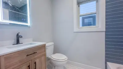 a bathroom with a toilet and a sink and a window at Pristine Pad, Sleep 9, Free driveway park, 20 PERCENT OFF in East Newark