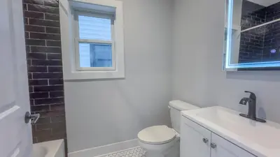 a bathroom with a toilet and a sink and a window at Pristine Pad, Sleep 9, Free driveway park, 20 PERCENT OFF in East Newark