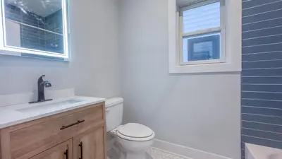 a bathroom with a toilet and a sink and a window at Pristine House, Sleep 21, Park 2 cars FREE, 20 PERCENT OFF in East Newark