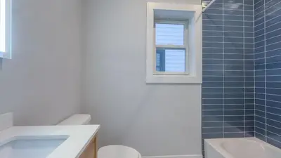 a bathroom with a sink and a toilet and a window at Pristine House, Sleep 21, Park 2 cars FREE, 20 PERCENT OFF in East Newark