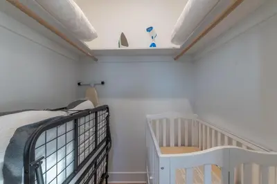 a bedroom with a bed and a crib at Pristine House, Sleep 21, Park 2 cars FREE, 20 PERCENT OFF in East Newark