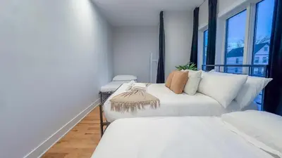 a white couch in a room with windows at Pristine House, Sleep 21, Park 2 cars FREE, 20 PERCENT OFF in East Newark