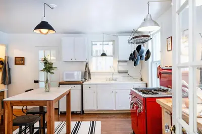 a kitchen with white cabinets and a red stove at The Swiss Hill Farmhouse - 5 Bedrooms w Hot Tub in Jeffersonville