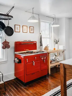 a red stove in a kitchen with a table at The Swiss Hill Farmhouse - 5 Bedrooms w Hot Tub in Jeffersonville