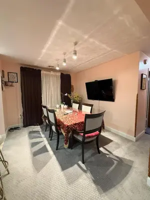 a dining room with a table with chairs and a television at House For Rent Near MetLife Stadium in Hasbrouck Heights