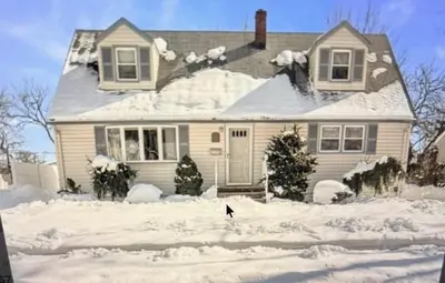 a house with snow on the ground in front of it at House For Rent Near MetLife Stadium in Hasbrouck Heights