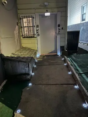 a walkway leading to a door with lights on it at EWRBNB - Rare Find! Huge 3BR Apartment with Open Layout minutes from Newark Airport & NYC - Apartment # 2 in Elizabeth
