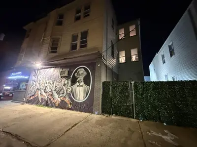 a building with a mural on the side of it at night at EWRBNB - Rare Find! Huge 3BR Apartment with Open Layout minutes from Newark Airport & NYC - Apartment # 2 in Elizabeth