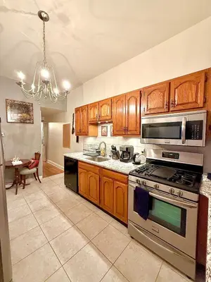 a kitchen with wooden cabinets and a stove top oven at Home away from home, Classic Victorian Haven in Harrisburg