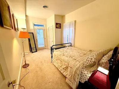 a bedroom with a bed and a lamp and a window at Home away from home, Classic Victorian Haven in Harrisburg