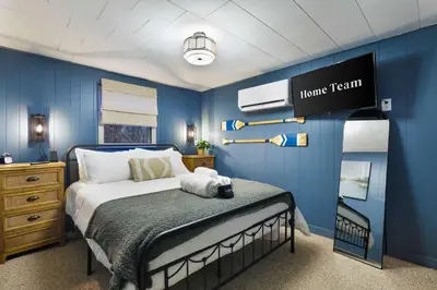 a bedroom with a bed with a blue wall at Evergreen Escape Hot Tub Firepit Resort Pool in Thornhurst