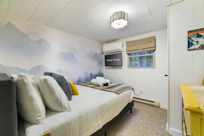 a bedroom with a large bed with a mural on the wall at Evergreen Escape Hot Tub Firepit Resort Pool in Thornhurst