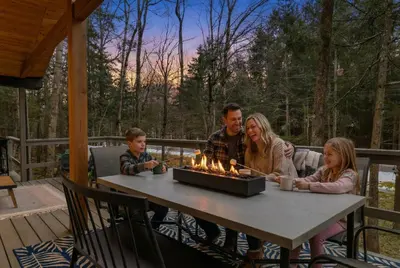 a family sitting at a table with a fire pit at Evergreen Escape Hot Tub Firepit Resort Pool in Thornhurst