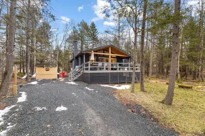 a house in the middle of a forest at Evergreen Escape Hot Tub Firepit Resort Pool in Thornhurst