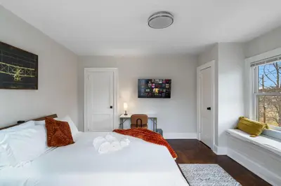a bedroom with a white bed and a window at 5BR Home Minutes to NYC and FIFA 2026 Sleeps 16 in Teaneck