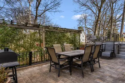 a table and chairs on a patio with a fence at 5BR Home Minutes to NYC and FIFA 2026 Sleeps 16 in Teaneck