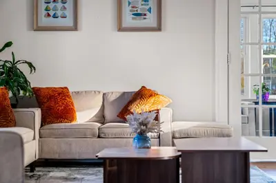 a living room with a couch and two tables at 5BR Home Minutes to NYC and FIFA 2026 Sleeps 16 in Teaneck