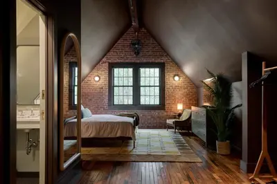 a bedroom with a bed and a brick wall at Eleanor Inn - Suite Amelia in Warwick