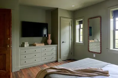 a bedroom with a television and a dresser with a mirror at Eleanor Inn - Suite Amelia in Warwick
