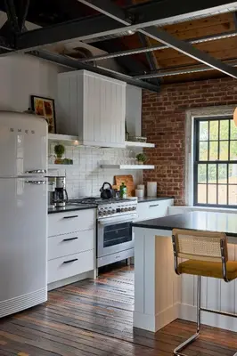 a kitchen with white appliances and a brick wall at Eleanor Inn - Suite Amelia in Warwick