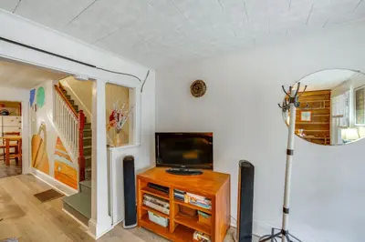 a living room with a tv and a table with a television at WFH Space and Yard! Walkable Lancaster Row Home in Lancaster