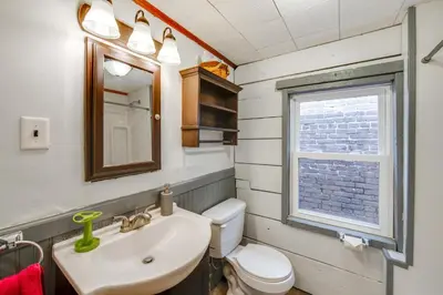 a bathroom with a sink and a toilet and a window at WFH Space and Yard! Walkable Lancaster Row Home in Lancaster