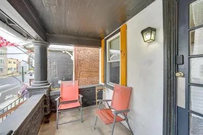 three chairs sitting on a porch next to a window at WFH Space and Yard! Walkable Lancaster Row Home in Lancaster
