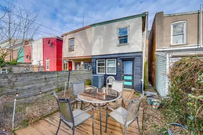 a patio with a table and chairs in front of a building at WFH Space and Yard! Walkable Lancaster Row Home in Lancaster