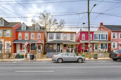 a car parked on the side of a street with houses at WFH Space and Yard! Walkable Lancaster Row Home in Lancaster