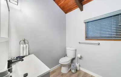 a white bathroom with a toilet and a sink at Peaceful 4 Bedroom Home located near Lake in Hawley
