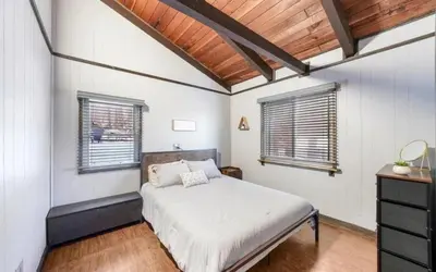 a bedroom with a bed and two windows at Peaceful 4 Bedroom Home located near Lake in Hawley