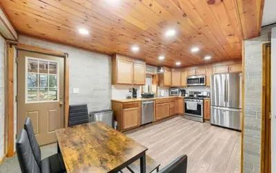 a kitchen with a wooden ceiling and a table and chairs at Peaceful 4 Bedroom Home located near Lake in Hawley
