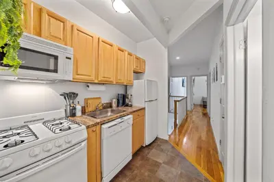 a kitchen with white appliances and wooden cabinets at Suite Double Room with shared bathroom in Times Square in New York