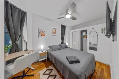 a bedroom with a bed and a desk and a window at Suite Double Room with shared bathroom in Times Square in New York