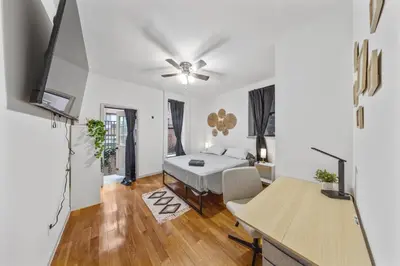 a white room with a bed and a desk at Suite Double Room with shared bathroom in Times Square in New York