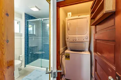 a small bathroom with a washer and dryer in it at Year-Round Fun on Lake Sheridan! Home with Patio