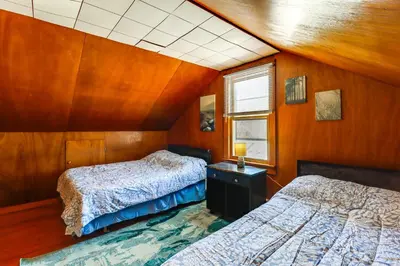 two beds in a room with wooden walls at Year-Round Fun on Lake Sheridan! Home with Patio