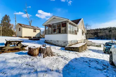 a house in a yard with snow on the ground at Year-Round Fun on Lake Sheridan! Home with Patio