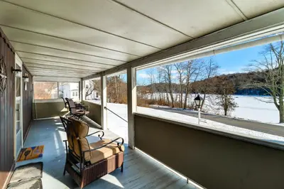 a screened porch with a chair and a large window at Year-Round Fun on Lake Sheridan! Home with Patio