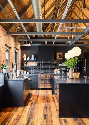 a large kitchen with black cabinets and black counter tops at Eleanor Inn - Suite Lorena in Warwick